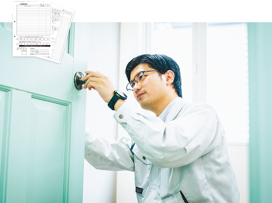 ドアの定期点検を行うスタッフ