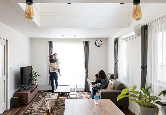 リビングで子どもを抱えて過ごす家族の様子